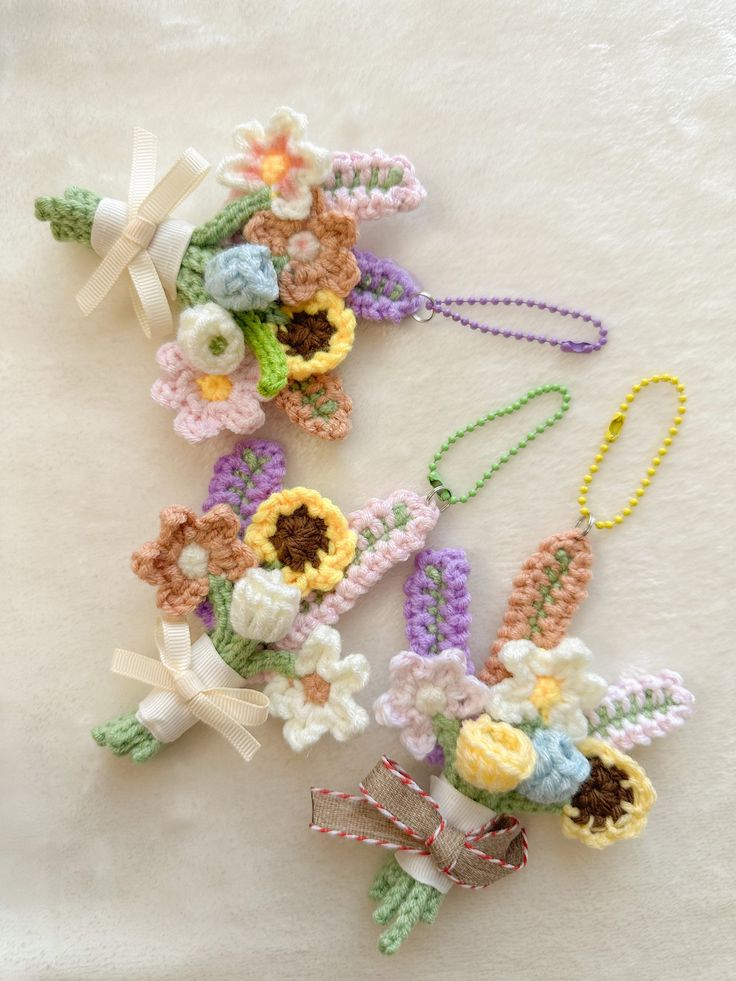 crocheted flowers and ribbons are laid out on a white surface, with ribbon around them