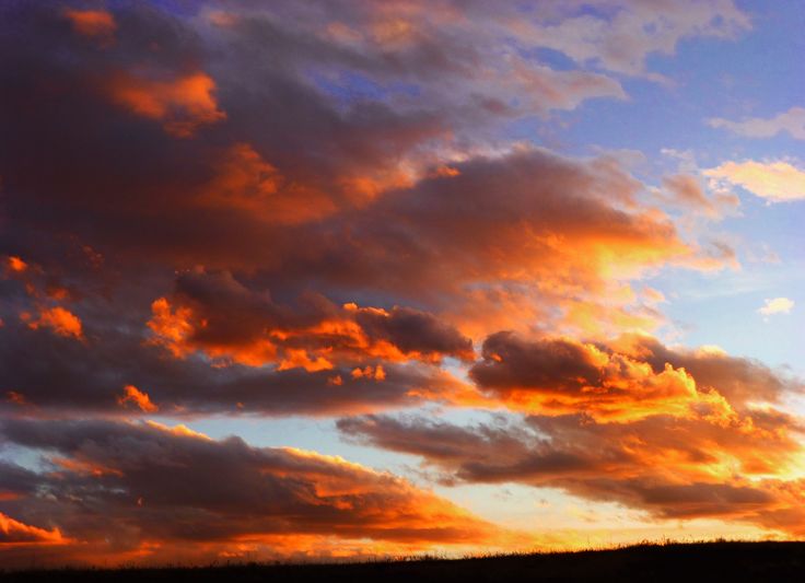 the sky is filled with clouds as the sun sets