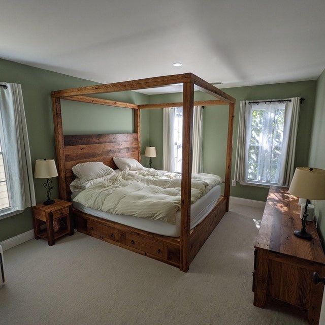 a large bed sitting in the middle of a bedroom next to two lamps and a window