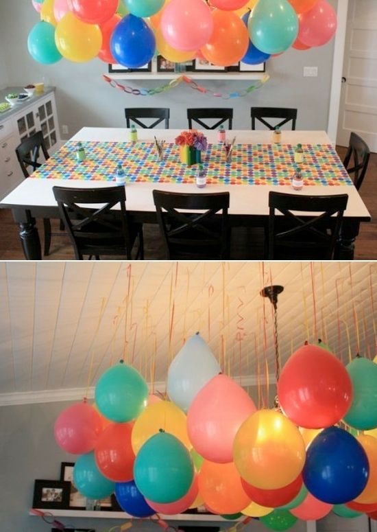 balloons are hanging from the ceiling above a dining room table