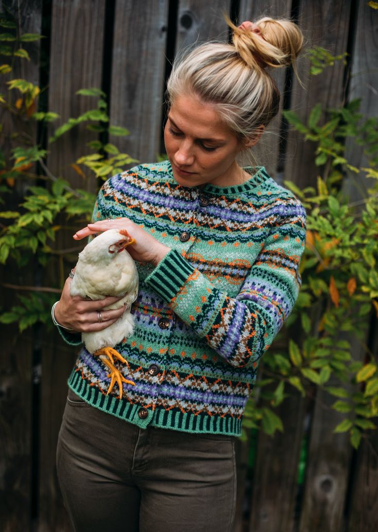 a woman holding a chicken in her hands