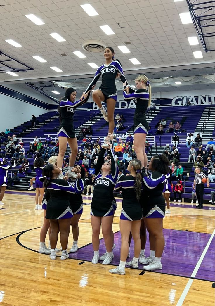 the cheerleaders are doing tricks on the basketball court