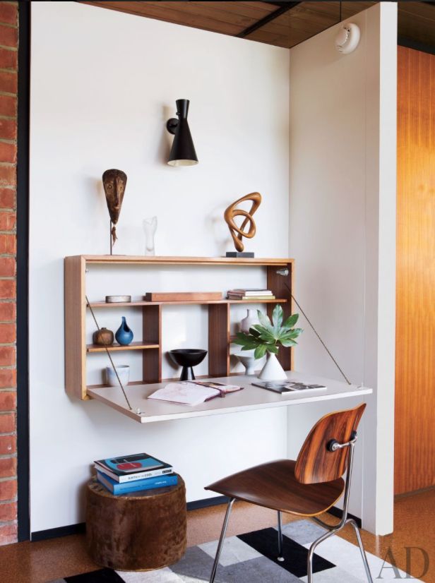 a room with a chair, desk and shelves on the wall above it is a black and white checkered floor