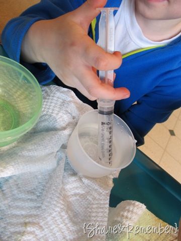 a young boy is holding a test tube in one hand and an empty container in the other