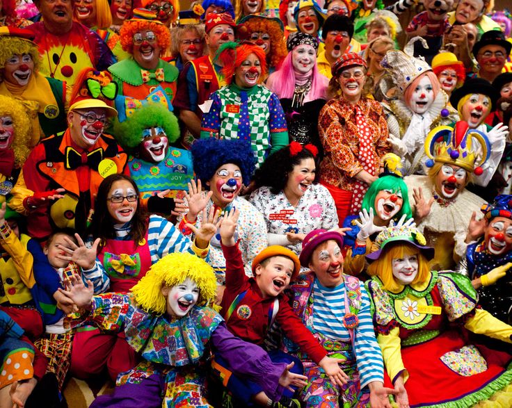 a large group of clowns are posing for the camera