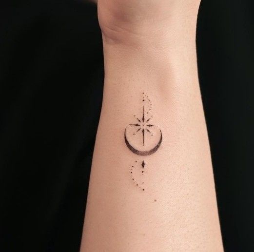 a woman's wrist with a star and crescent tattoo on the left side of her arm