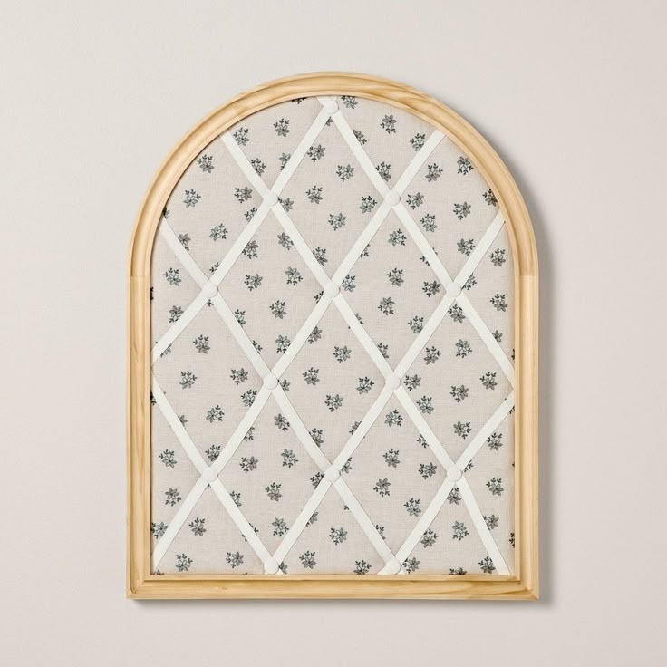 an arched window with floral designs on the outside, and wooden trim around the edges