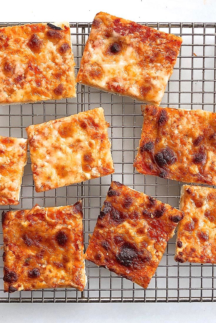 nine square pieces of pizza on a cooling rack