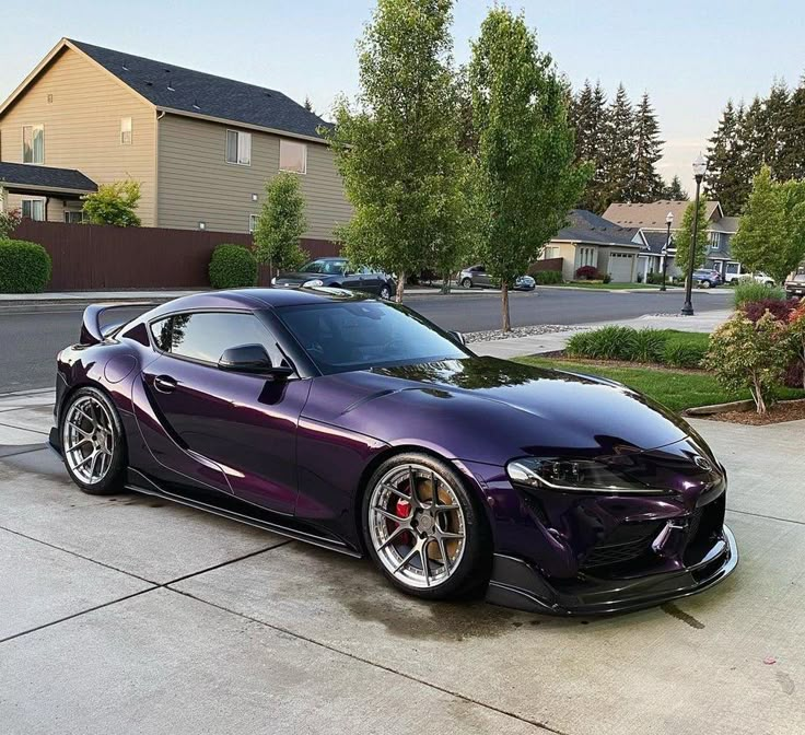 a purple sports car parked in front of a house