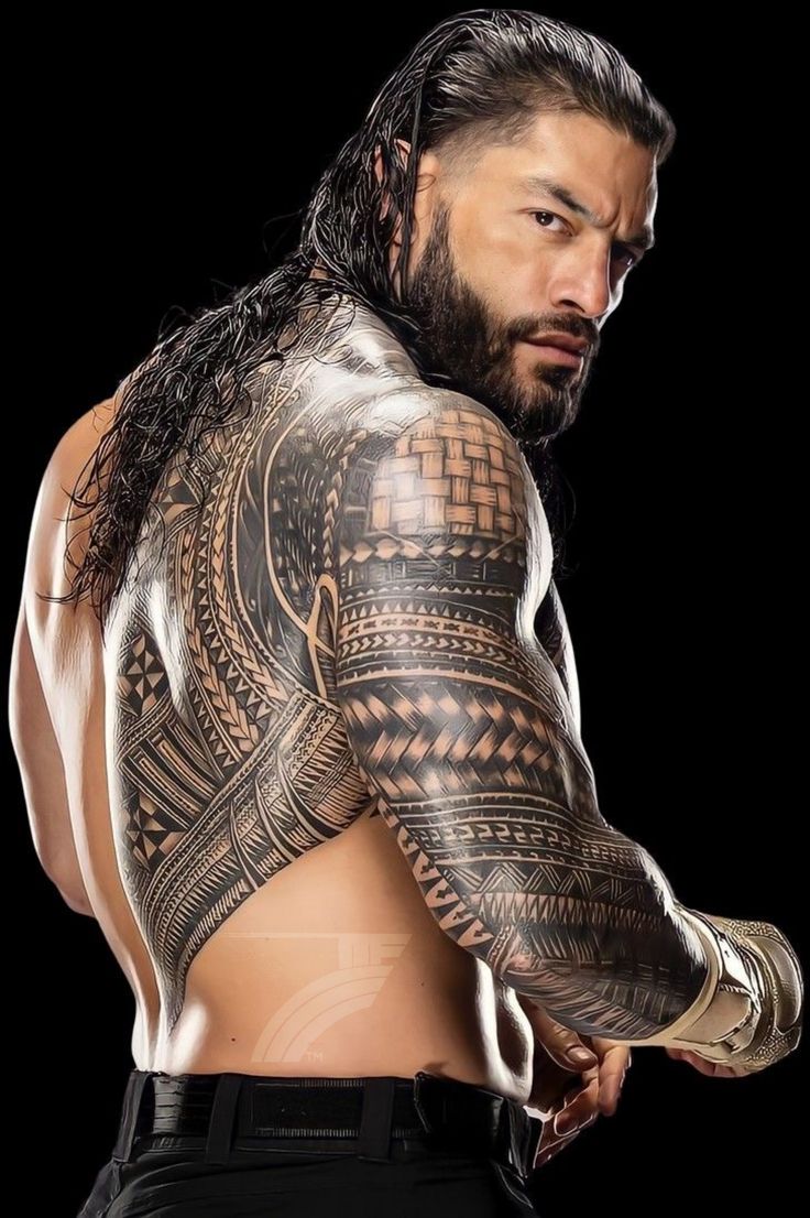 a man with long hair and tattoos on his arm