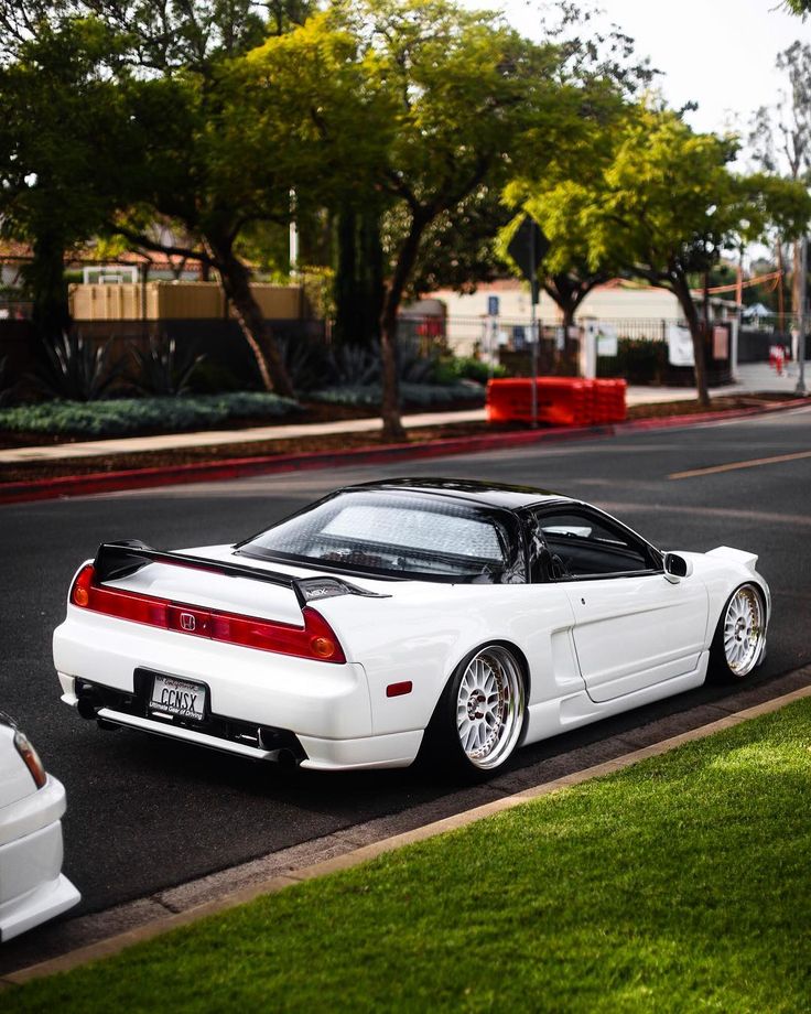 a white sports car parked on the side of the road