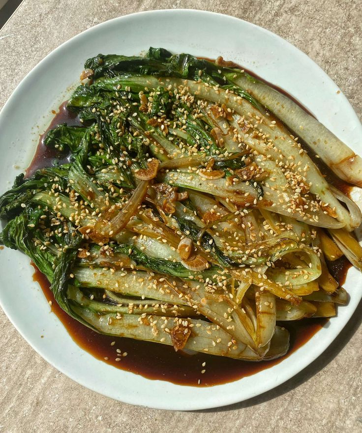 a white plate topped with broccoli covered in sesame seeds