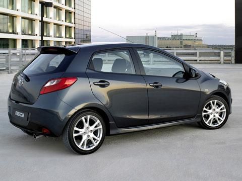 a small black car parked in a parking lot