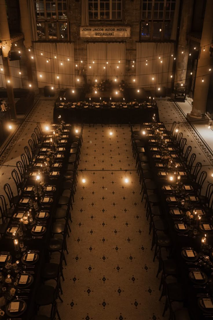 an overhead view of a dining hall with many tables and chairs lit up at night