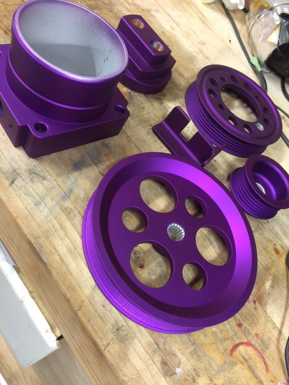 purple plastic parts sitting on top of a wooden table