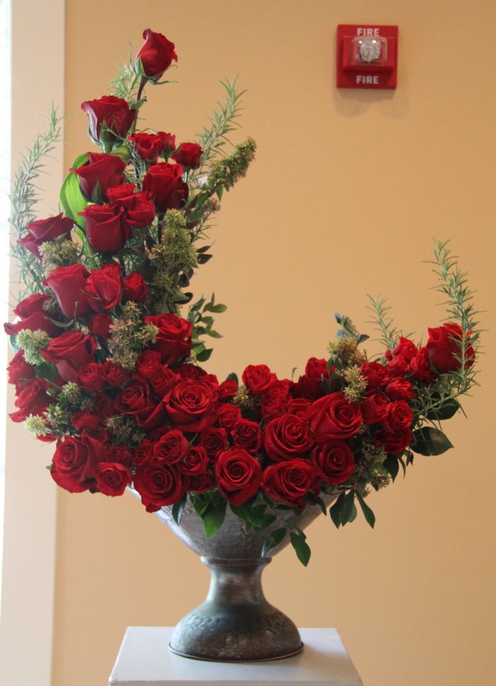 a vase filled with red roses on top of a table