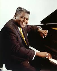 a man in a suit and tie sitting at a piano