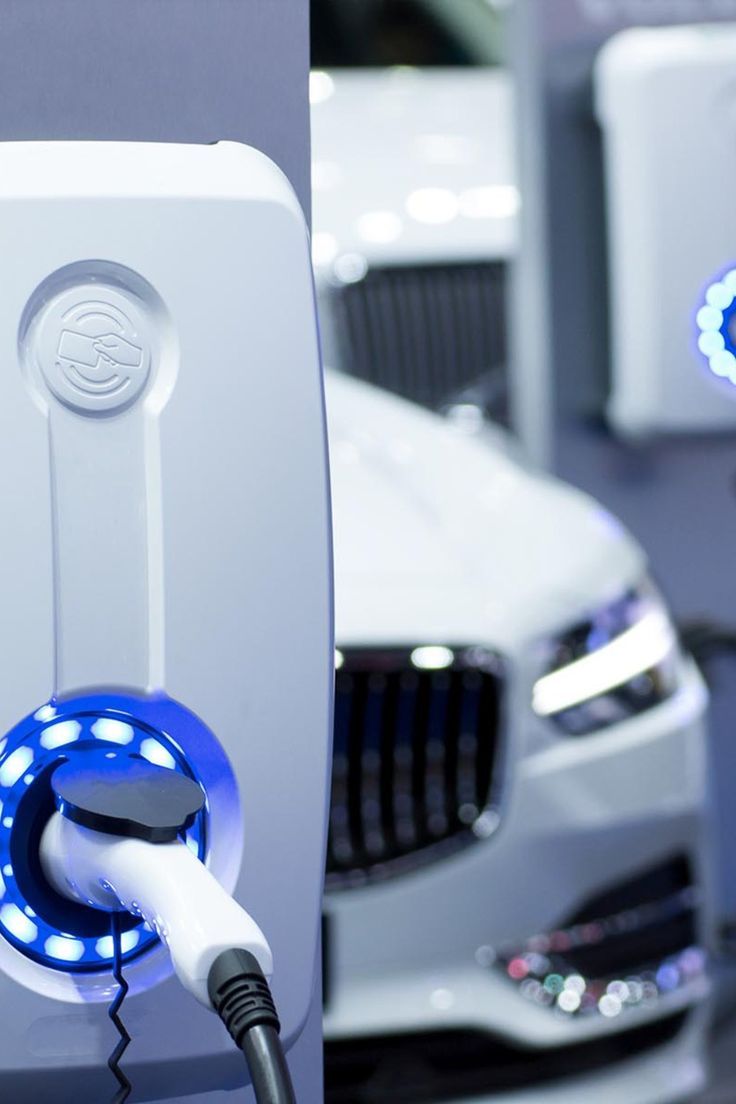 an electric car plugged in to a charger with blue lights on the front