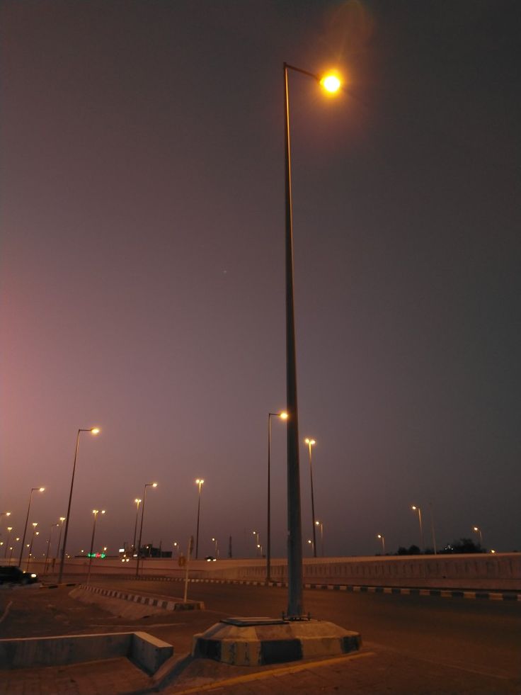 an empty parking lot at night with street lights