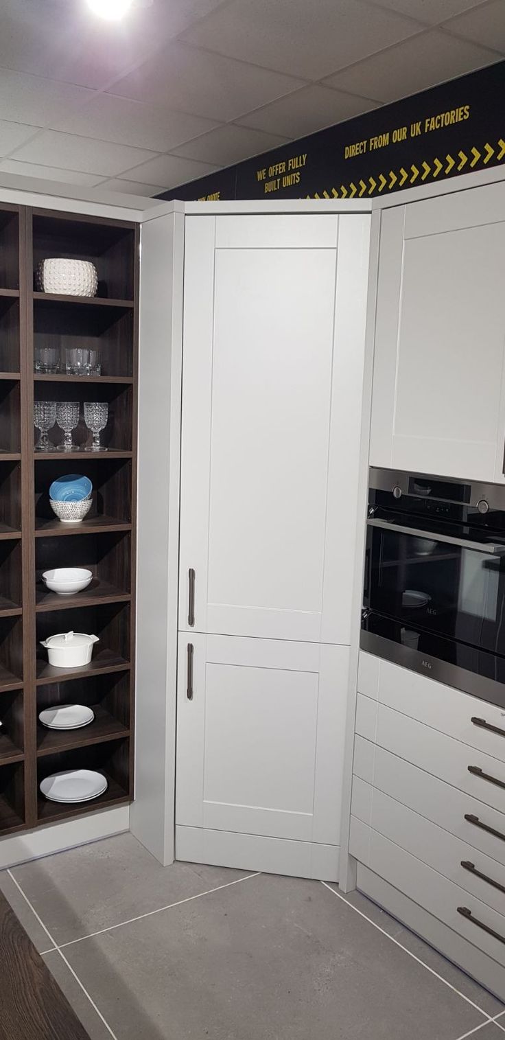 a kitchen with white cupboards and glassware on the shelves