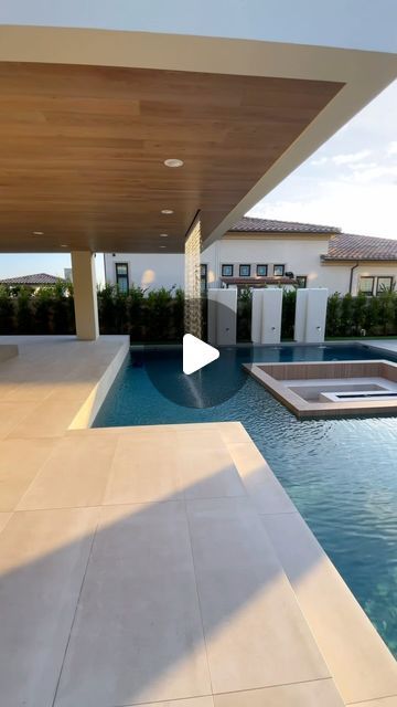 a house with a swimming pool in front of it and an open patio area to the side