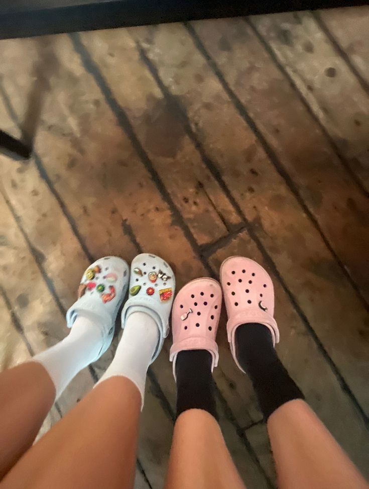 three pairs of white and pink shoes sitting next to each other on a wooden floor