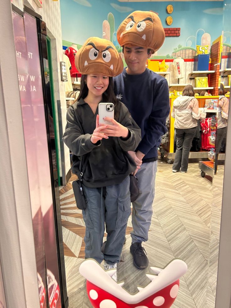 a man and woman taking a selfie in front of a cartoon character toilet seat