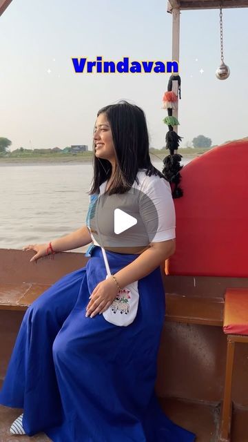 a woman sitting on top of a boat next to the ocean with her hand in her pocket