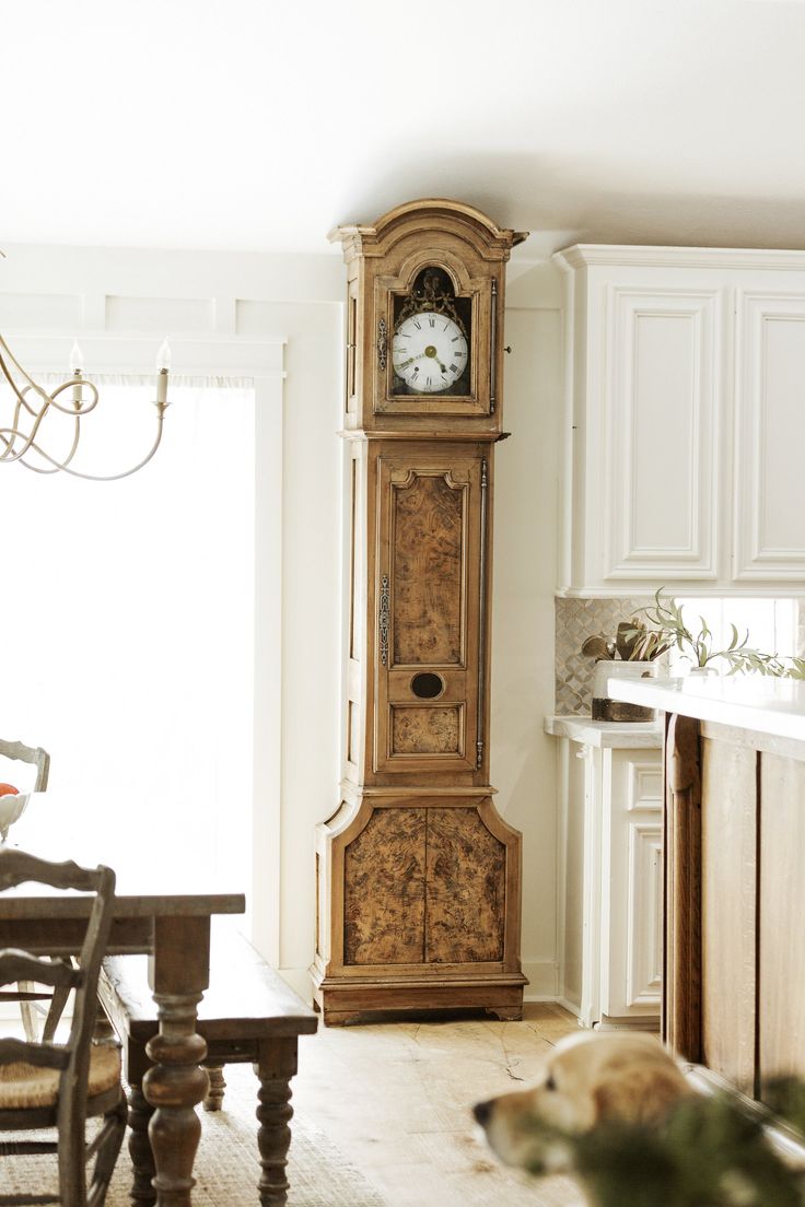 an old grandfather clock in the corner of a kitchen