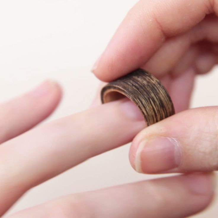 a person holding a ring in their left hand while another person holds it up to the camera