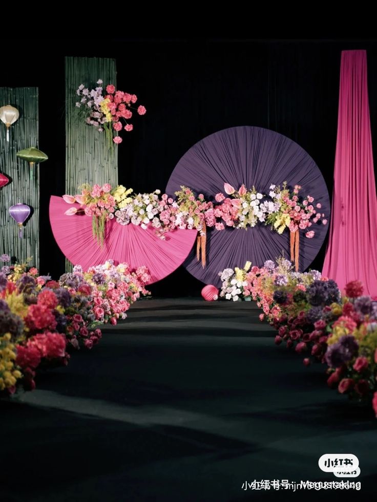 an image of a stage setting with flowers and umbrellas