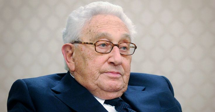 an older man in a suit and tie sitting down