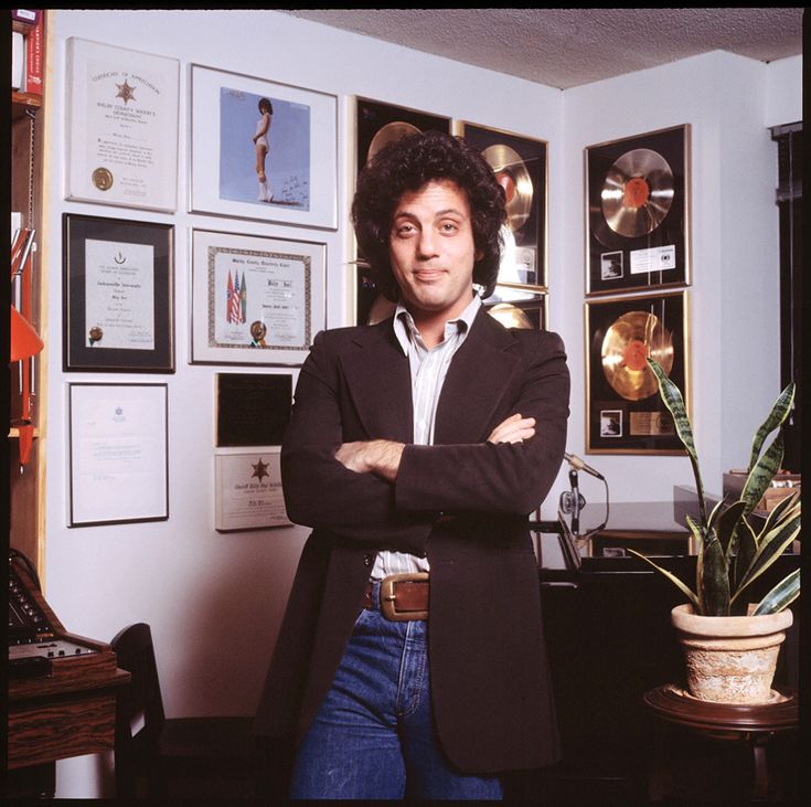 a man standing in front of a desk with his arms crossed