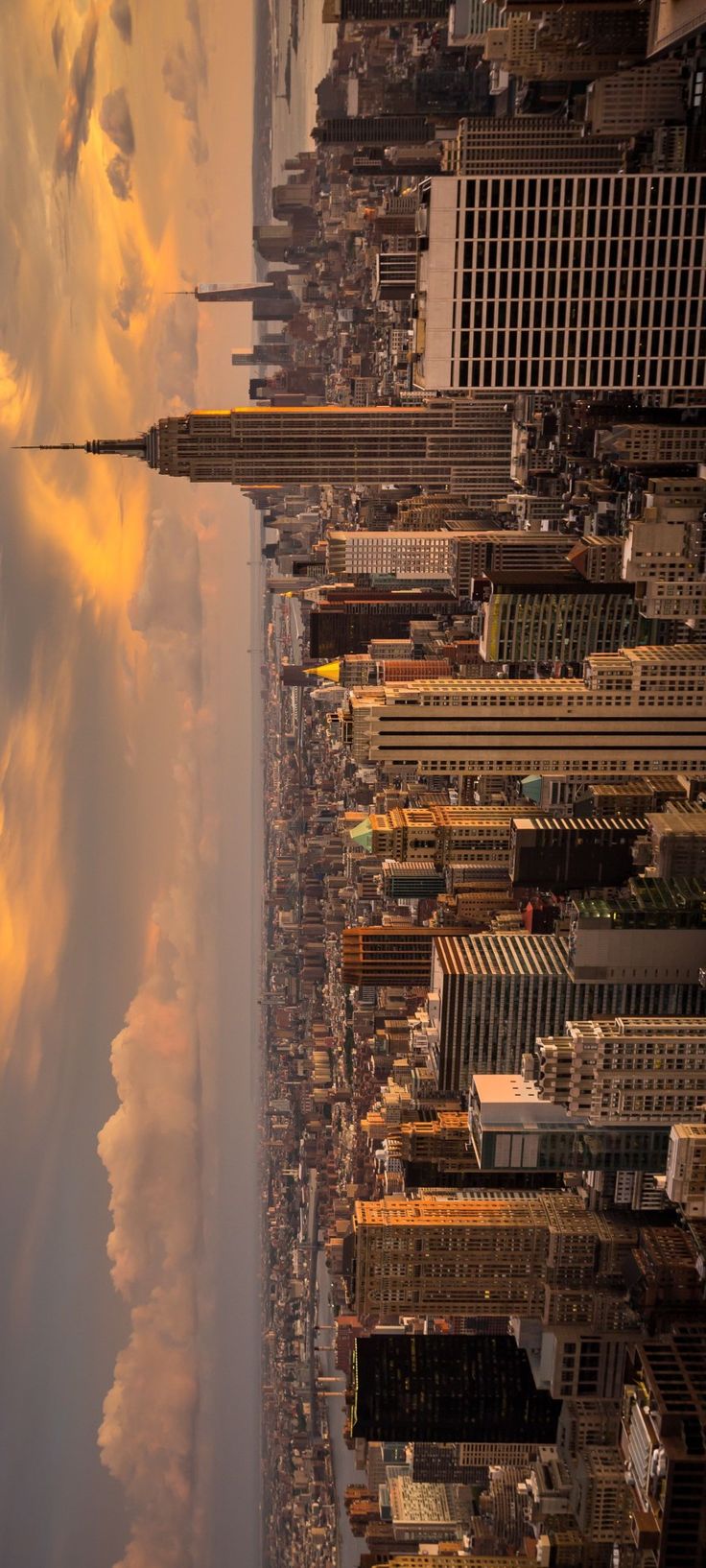 an aerial view of new york city with clouds in the sky and skyscrapers on either side