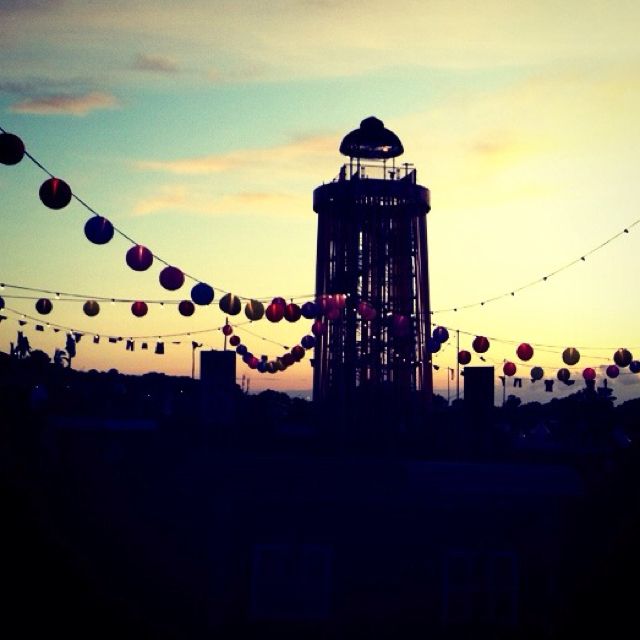 there is a tower that has some lights on it in the sky and many balls are hanging around