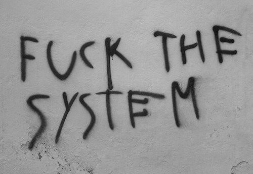 graffiti written on the side of a wall that says,'f k the system '