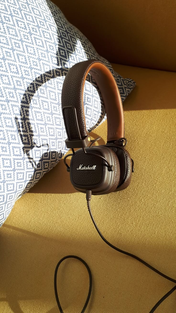 headphones are sitting on top of a pillow