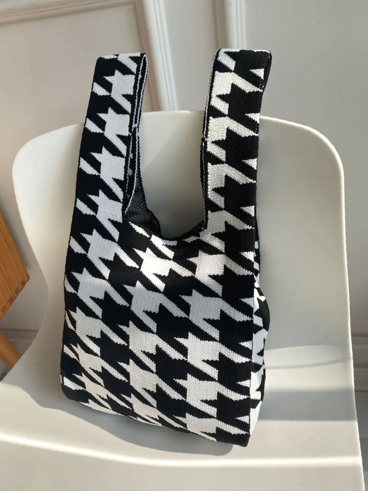 a black and white bag sitting on top of a chair