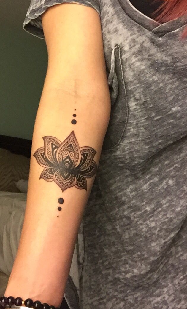 a woman's arm with a tattoo on it and a lotus flower in the middle