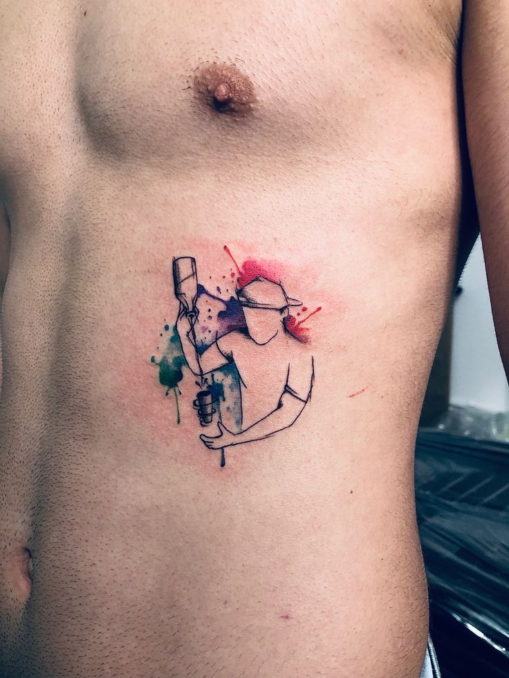 a man's stomach with an anchor and watercolor splattered on it