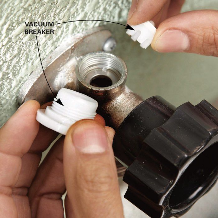 a person fixing a water inlet on a wall with screws and other parts attached to it