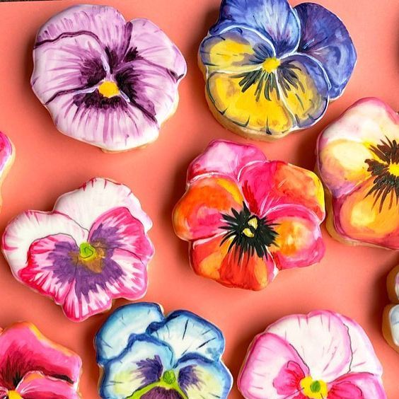 colorful pansies are arranged on an orange surface