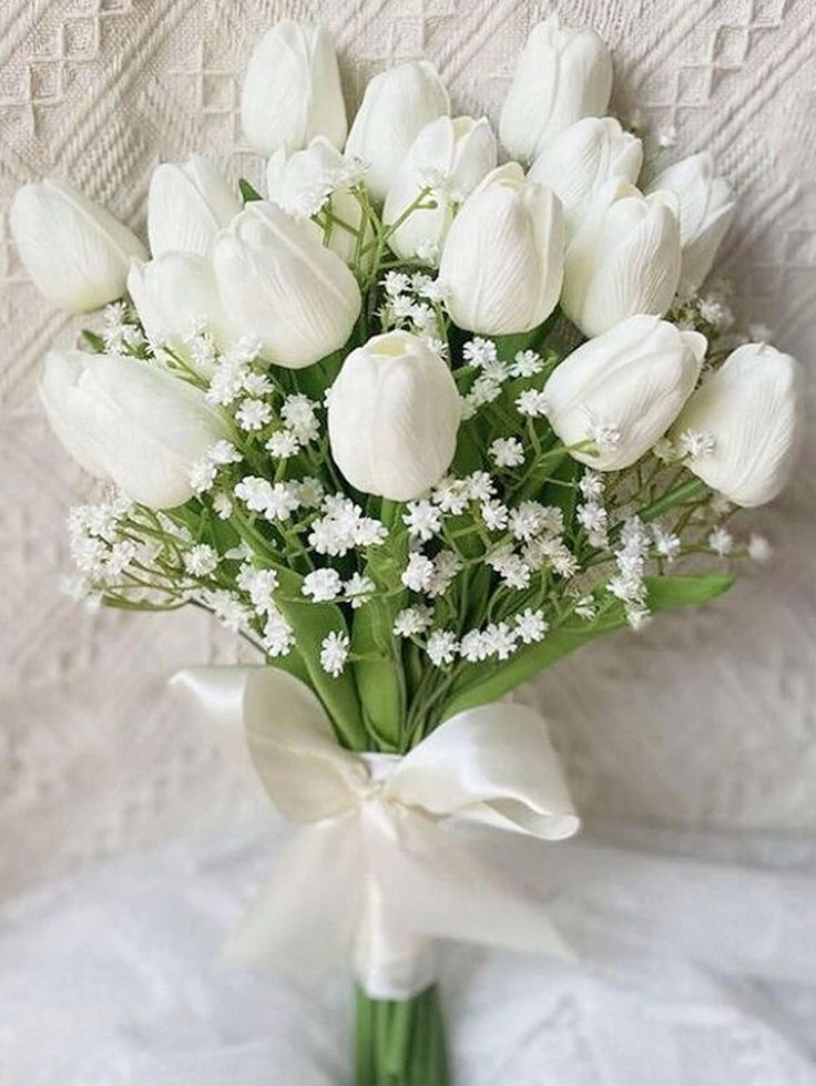 a bouquet of white tulips and baby's breath