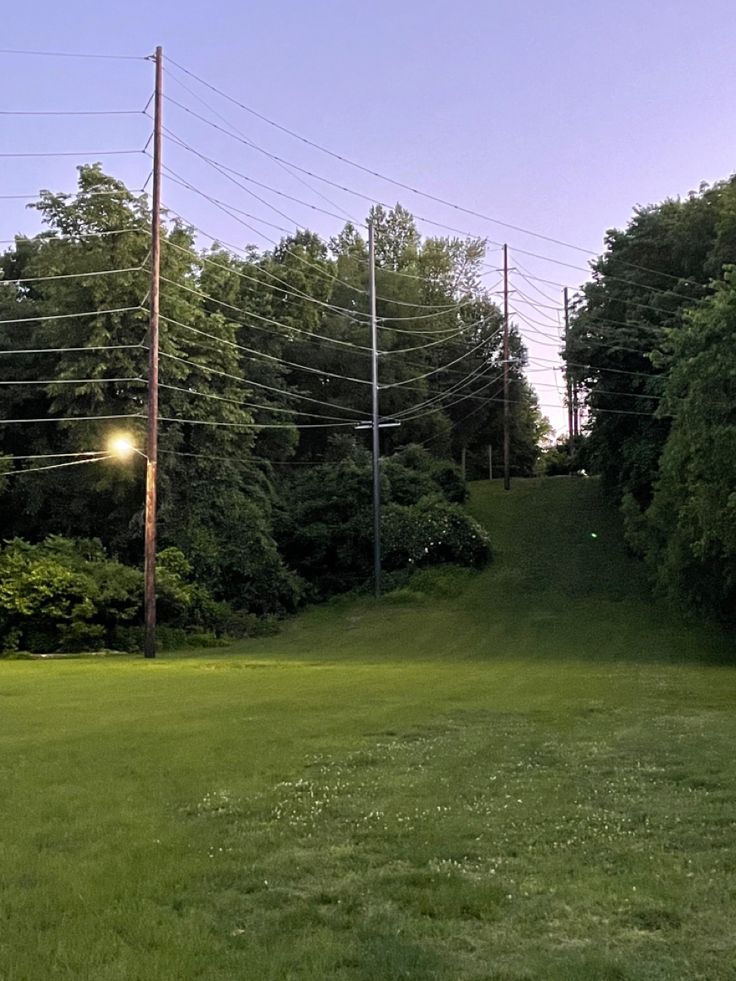 an empty field with power lines above it