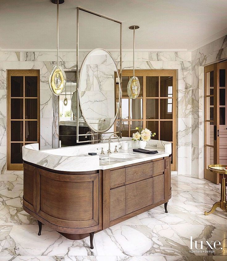 an elegant bathroom with marble floors and large mirrors on the wall, along with two sinks