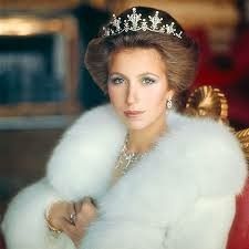 an old photo of a woman wearing a tiara and fur stole with jewels on her head