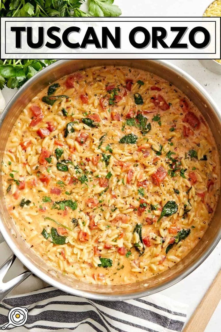 a pan filled with pasta and spinach on top of a table