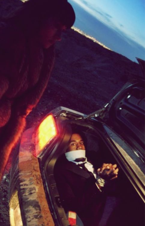 a man sitting in the back of a car next to a woman with her head out