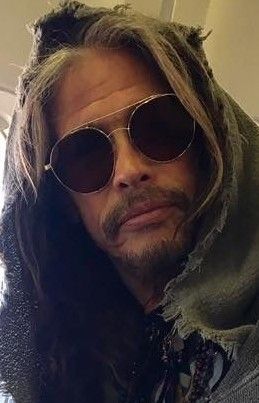 a man with long hair wearing sunglasses and a scarf