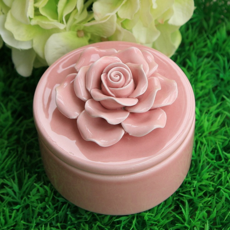 a pink flower shaped container sitting on top of green grass